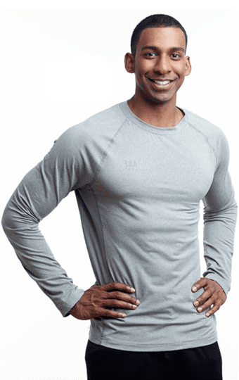 Male nutrition coach smiling with hands on hips.